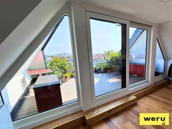Dachfenster und Schiebetür zur Dachterrasse mit Pflanzen und Stadtblick