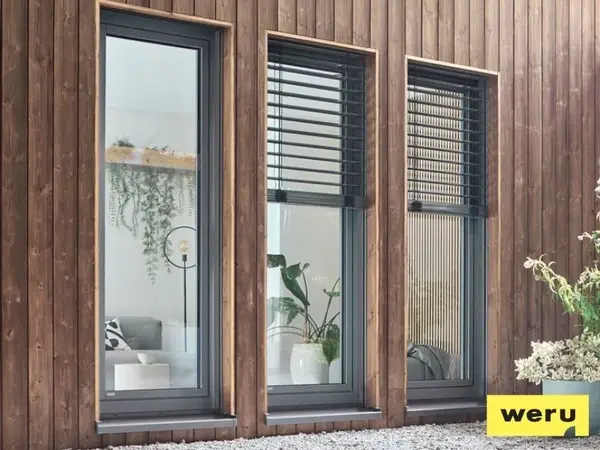Moderne bodentiefe Fenster mit Jalousien in Holzfassade, energieeffizient und stilvoll.