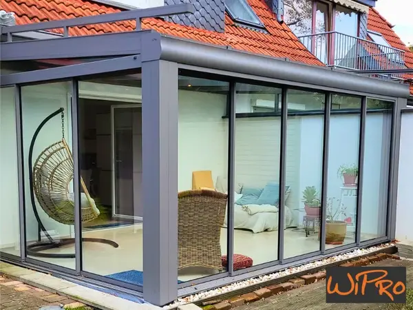 Moderner Wintergarten mit Glasfront am Haus, Sitzbereich und Hängesessel