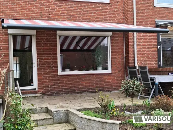Markise an Backsteinhaus über Terrasse und Fenster, Sonnenschutz außen