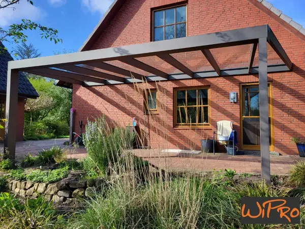 Moderne Terrassenüberdachung aus Aluminium am Backsteinhaus im Garten